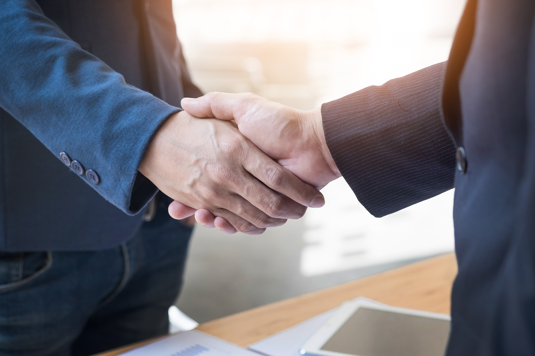 two people in suits shaking hands and leveraging business partnerships